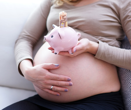 Schwangere mit Mutterschaftsgeld im Sparschwein