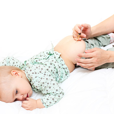 Baby bekommt eine Impfung in den Po verabreicht