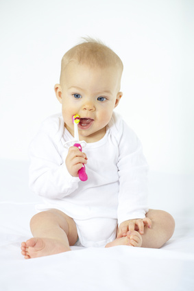 Baby mit Zahnbürste im Mund - Zahnpflege bei Babys ersten Zähnen