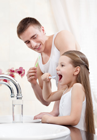 Vater und Tochter beim Zaehneputzen