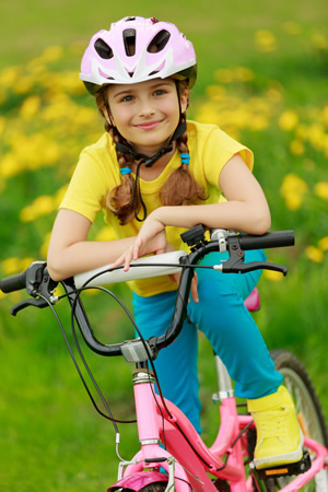 Kind mit Helm sicher auf dem Fahrrad unterwegs