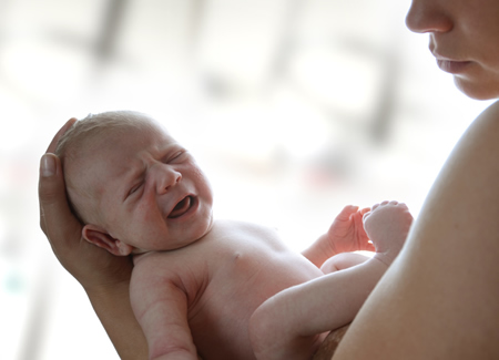 Mutter mit frischgeborenem Baby im Arm - in der 40 Schwangerschaftswoche ist der Geburtstermin